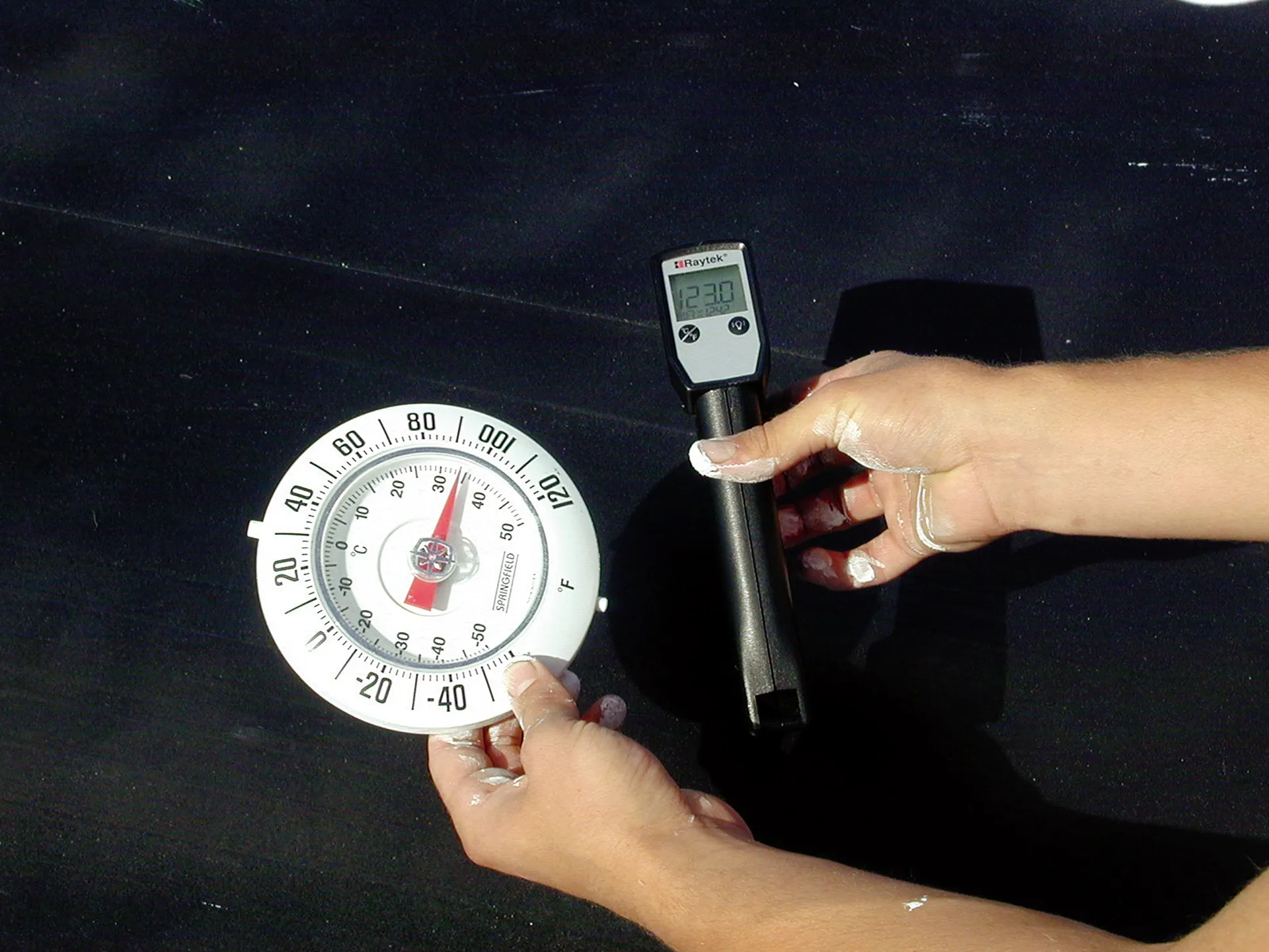 Thermometer showing a high surface temperature on a dark roof