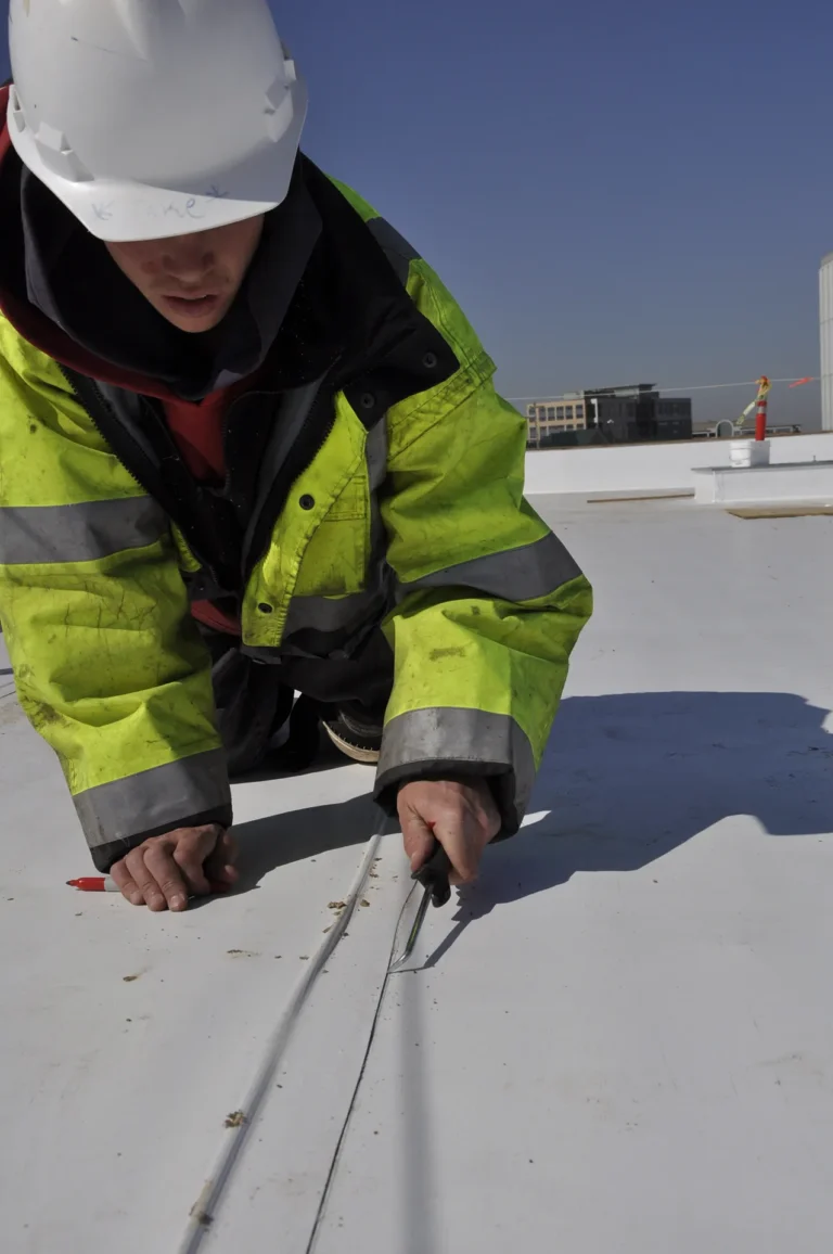 Roofer seaming single ply membrane on a flat commercial roof