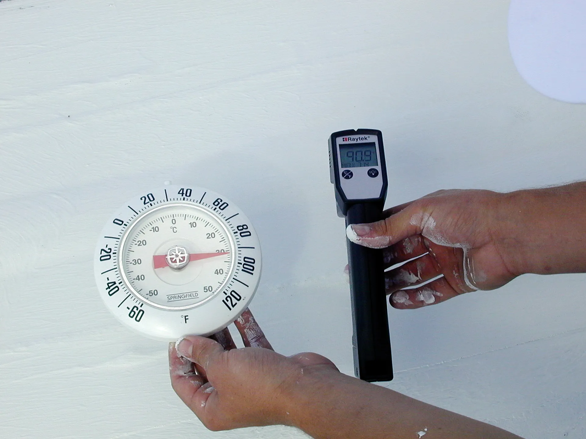 Thermometer showing a cool surface temperature on a white reflective roof